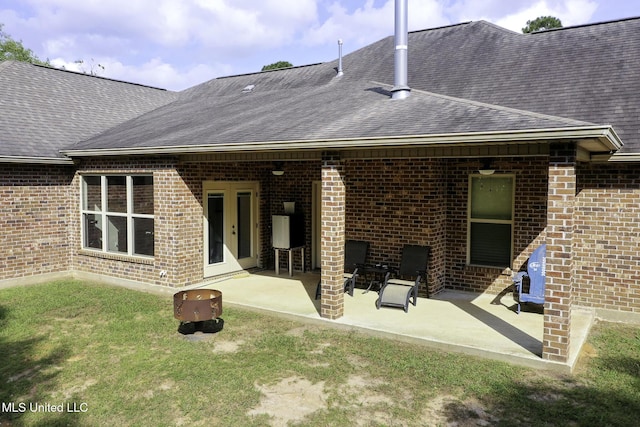 8185 Ridgewood Dr, Kiln, MS 39556 - rear view of property with brick siding, roof with shingles, a patio area, and a lawn