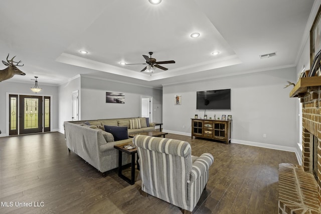 8185 Ridgewood Dr, Kiln, MS 39556 - living area featuring a raised ceiling, dark wood finished floors, a fireplace, a ceiling fan, and baseboards