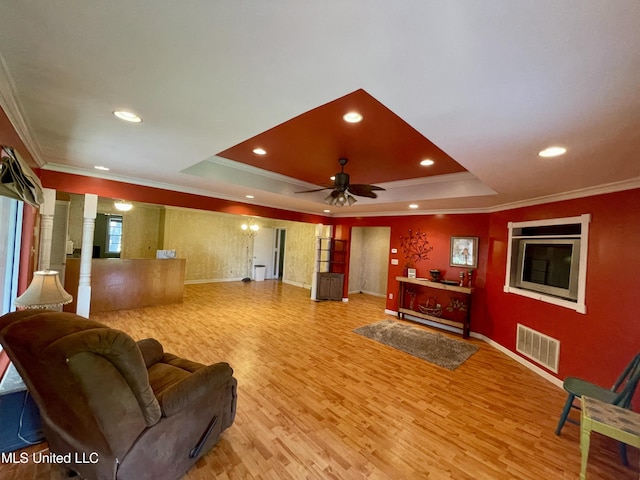 1103 N Yale St, Cleveland, MS 38732 - living room featuring crown molding, a tray ceiling, light wood-type flooring, ornate columns, and baseboards