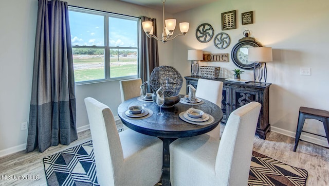 dining area featuring light hardwood / wood-style flooring, plenty of natural light, and a notable chandelier