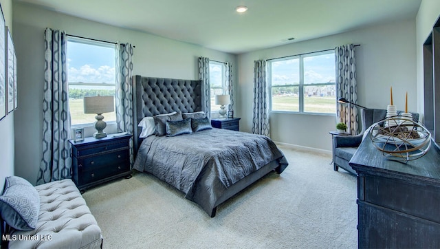 bedroom featuring light carpet and multiple windows