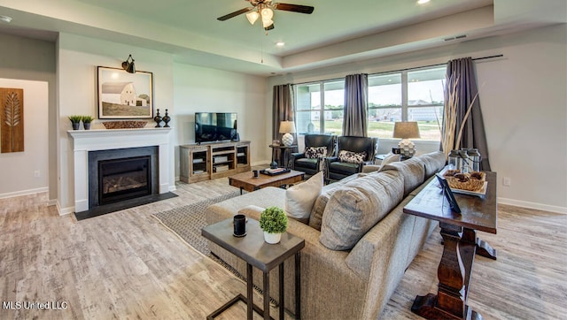 living room featuring ceiling fan and light hardwood / wood-style flooring