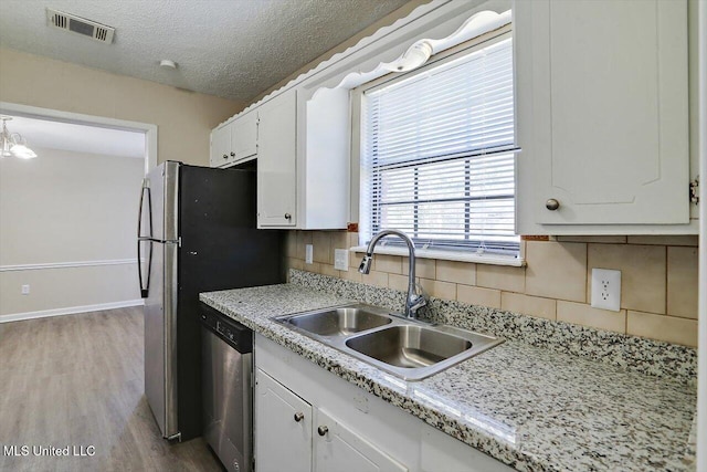 kitchen featuring sink, dishwasher, light hardwood / wood-style floors, decorative backsplash, and white cabinets