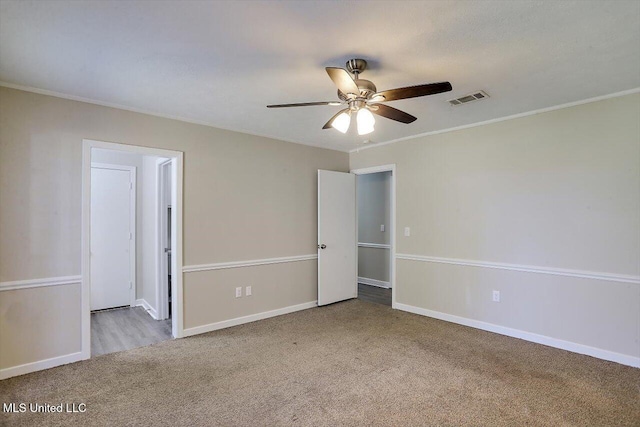 spare room featuring light carpet, crown molding, and ceiling fan