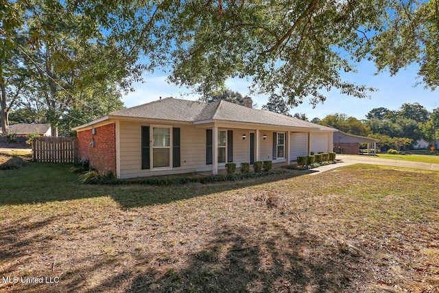 ranch-style house featuring a front yard and covered porch