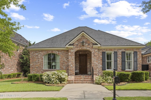 150 Harper St, Ridgeland, MS 39157 - view of front of home with brick siding, a front yard, central AC, and a shingled roof