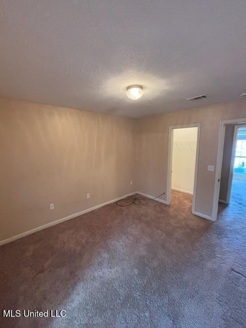 carpeted spare room featuring a textured ceiling