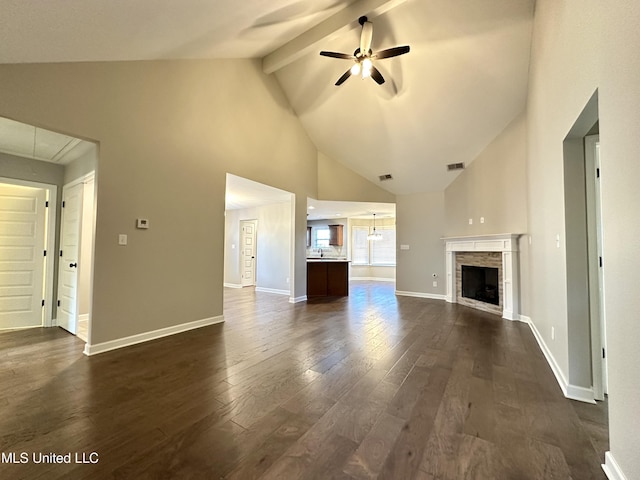 unfurnished living room featuring high vaulted ceiling, a tile fireplace, dark hardwood / wood-style floors, ceiling fan, and beam ceiling