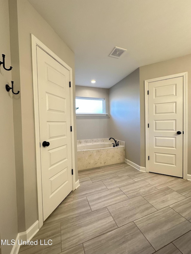 bathroom featuring tiled tub