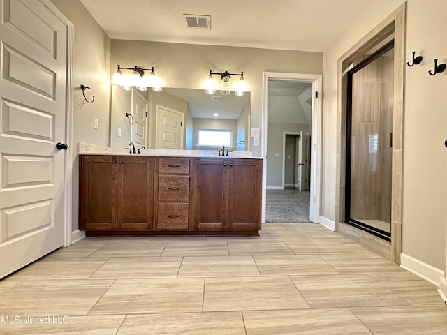 bathroom with a shower with door and vanity