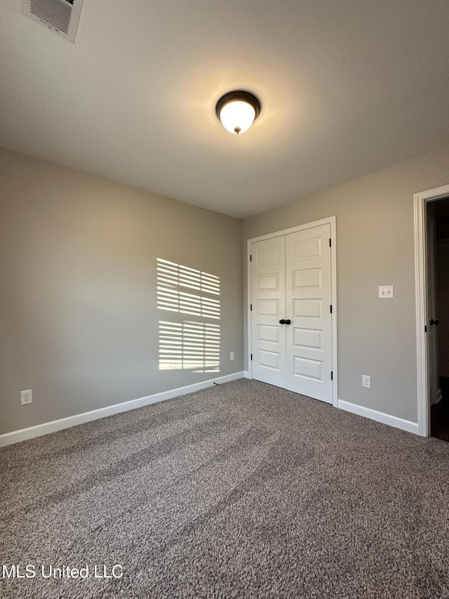 unfurnished bedroom featuring carpet flooring and a closet