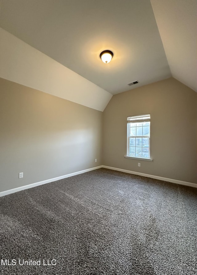 additional living space with carpet floors and vaulted ceiling