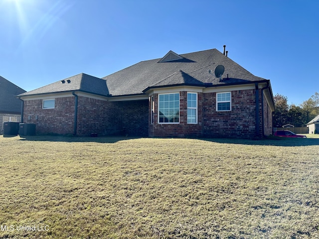 view of front of property featuring a front yard and central AC