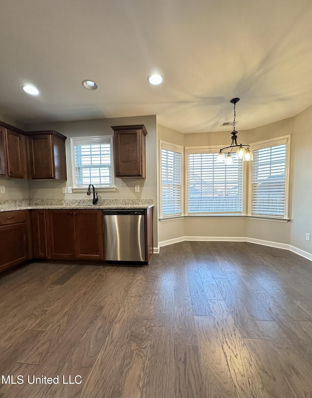 kitchen featuring dishwasher, pendant lighting, dark hardwood / wood-style floors, and light stone counters