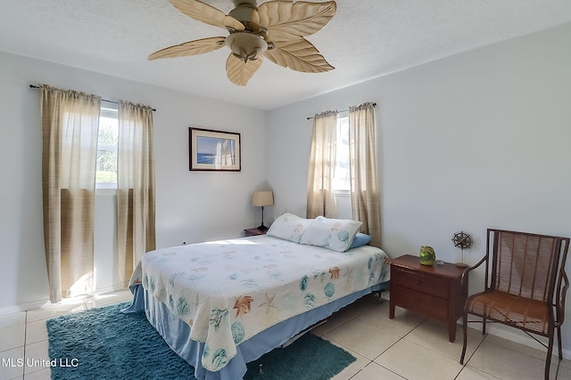 tiled bedroom with multiple windows, ceiling fan, and a textured ceiling