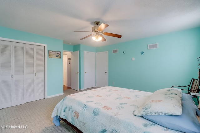 bedroom with ceiling fan, light colored carpet, a closet, and a textured ceiling