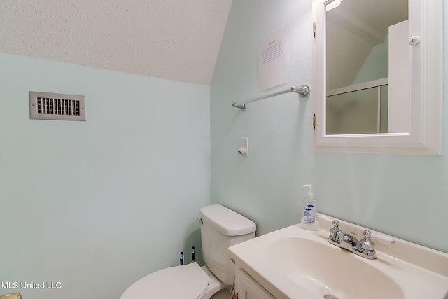 bathroom featuring vanity, toilet, and a textured ceiling