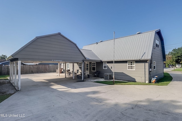 rear view of property featuring a carport and central air condition unit