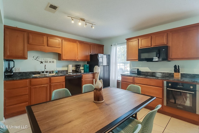 kitchen with sink, light tile patterned floors, and black appliances