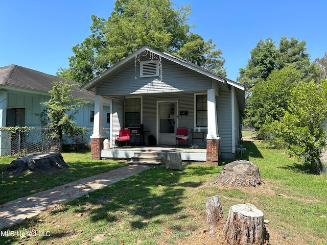 bungalow featuring a porch and a front lawn