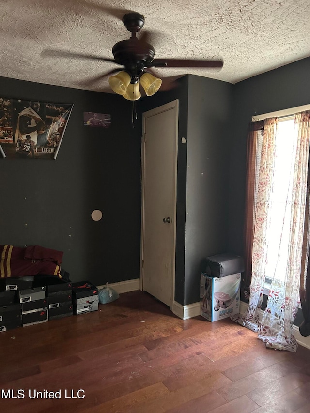 interior space featuring ceiling fan, a textured ceiling, and hardwood / wood-style floors