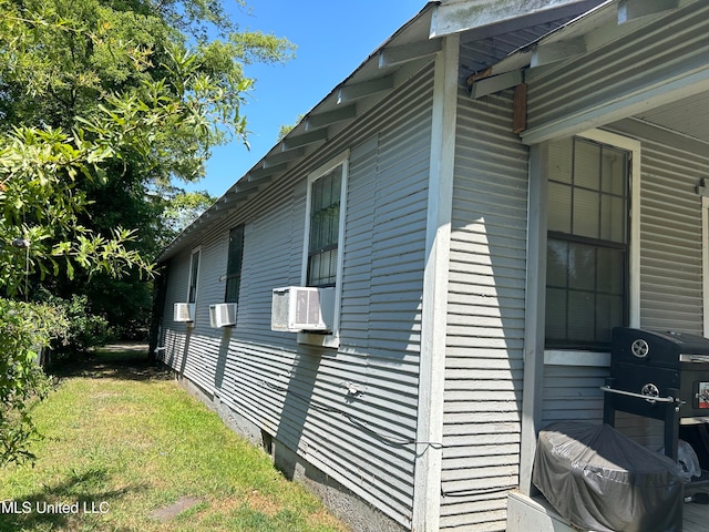 view of home's exterior featuring cooling unit and a lawn