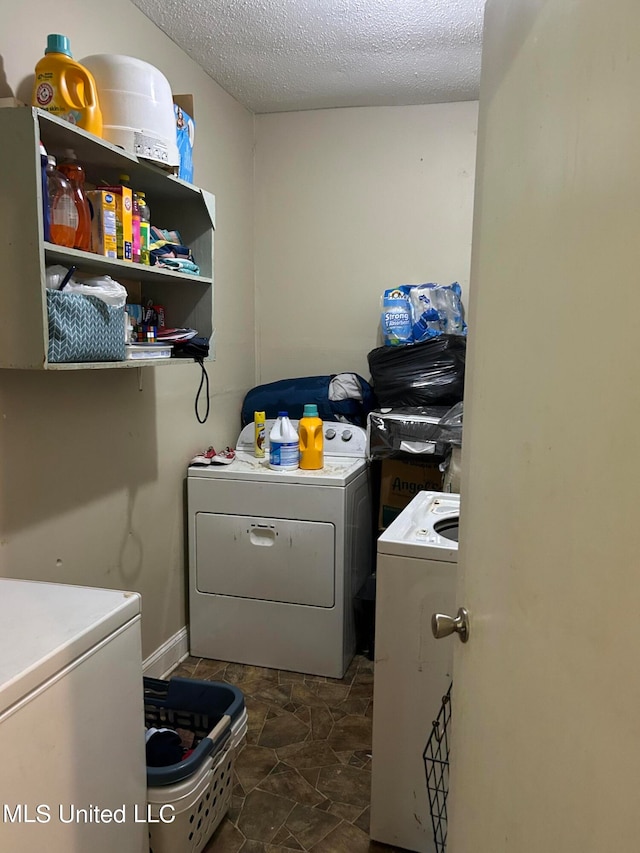 laundry room with a textured ceiling and washing machine and dryer