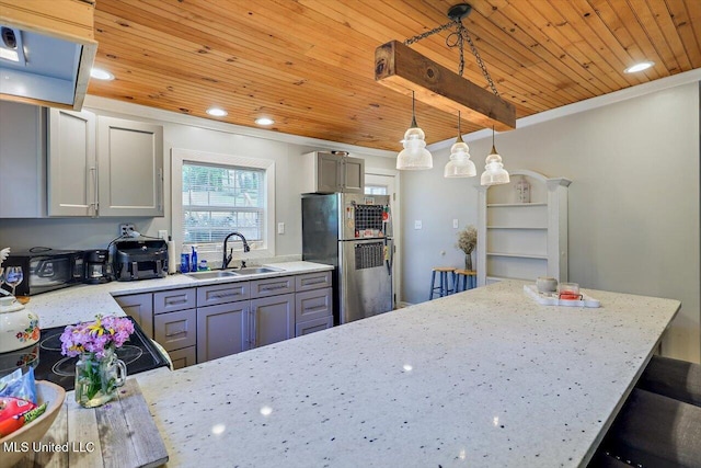 kitchen featuring wooden ceiling, freestanding refrigerator, a sink, and gray cabinets