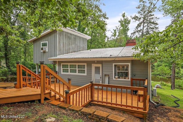 back of property with a wooden deck, board and batten siding, and metal roof