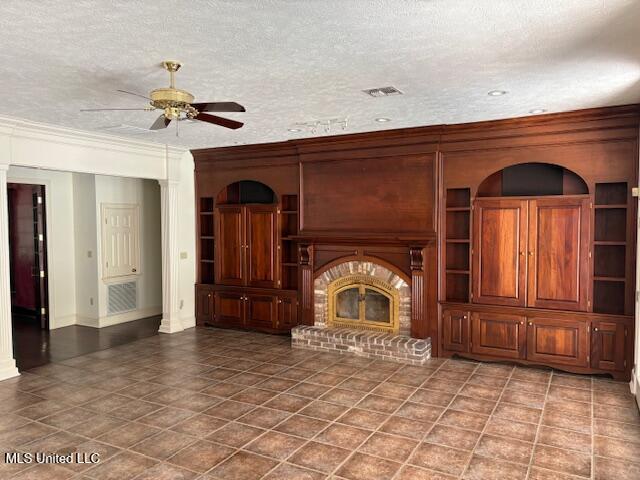 unfurnished living room featuring visible vents, a fireplace, baseboards, ceiling fan, and a textured ceiling