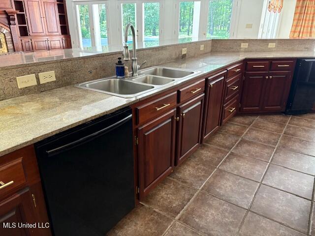 kitchen featuring a sink, black dishwasher, dark tile patterned flooring, and light countertops