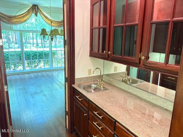 kitchen featuring a sink, glass insert cabinets, and dark brown cabinets