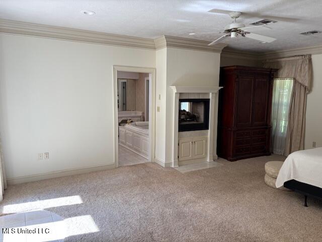 bedroom featuring light colored carpet, ornamental molding, a multi sided fireplace, and visible vents