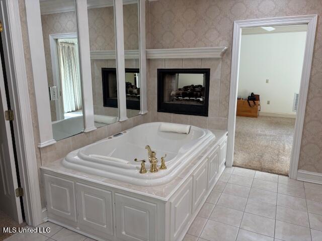 bathroom with a whirlpool tub, tile patterned flooring, and a fireplace