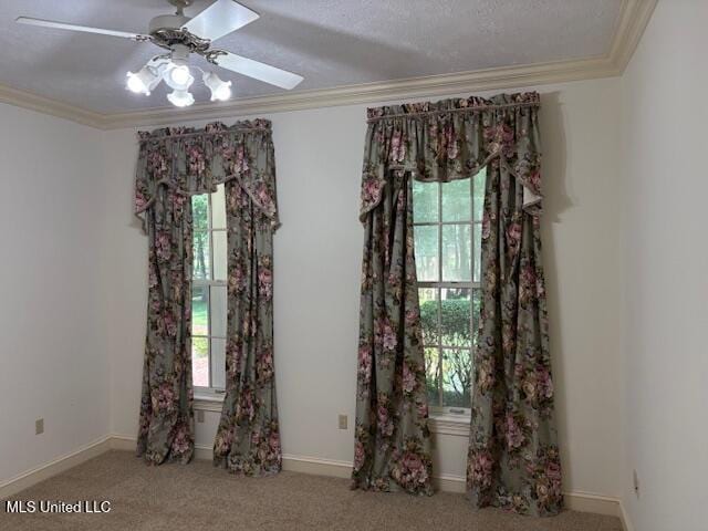 interior space with baseboards, ornamental molding, carpet, and a ceiling fan
