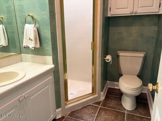 bathroom with vanity, tile patterned floors, a stall shower, and toilet