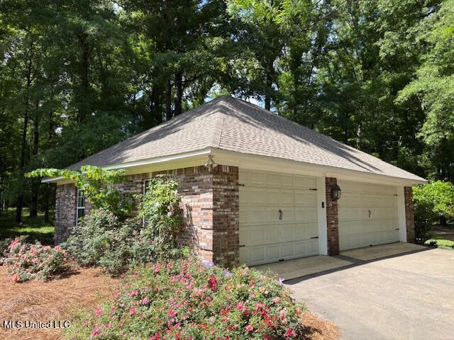 view of side of property with brick siding and a garage