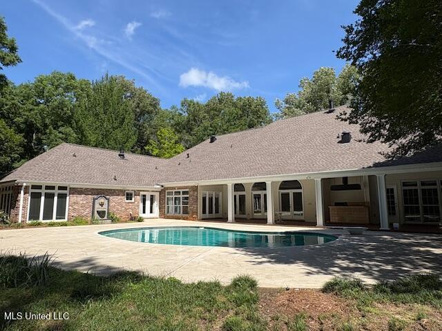 outdoor pool featuring a patio and french doors