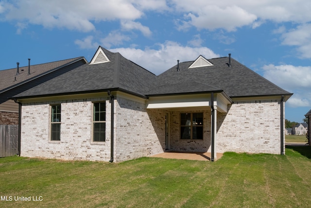 rear view of house with a yard and a patio