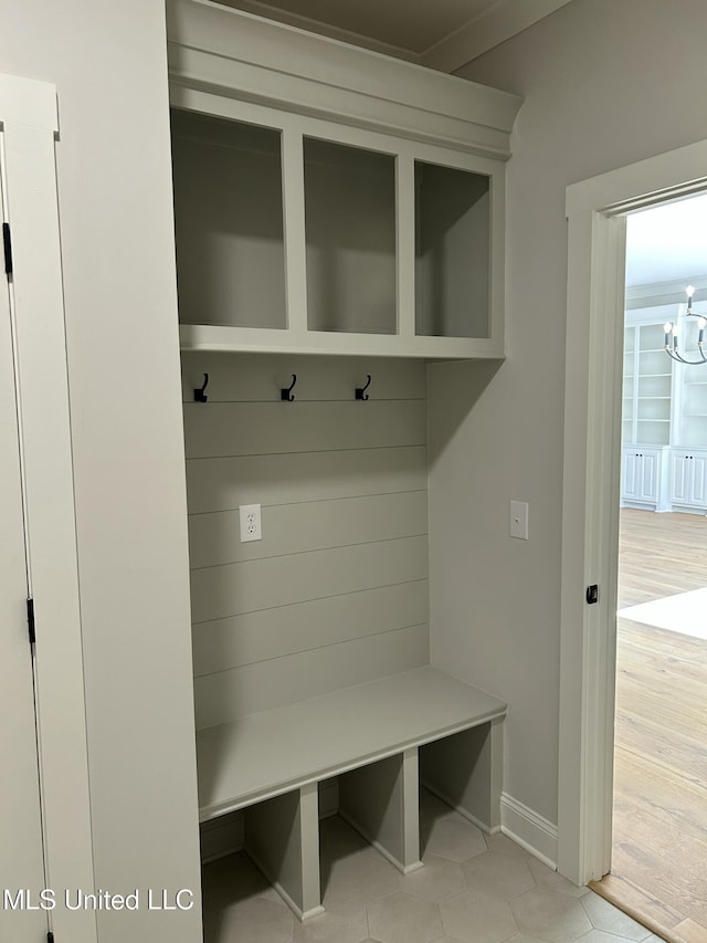 mudroom with baseboards and an inviting chandelier