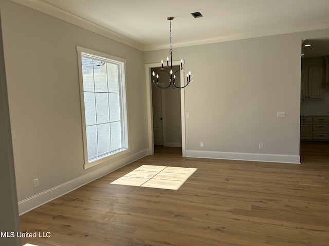 unfurnished dining area with baseboards, wood finished floors, and crown molding