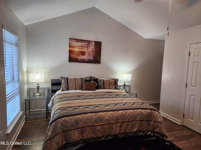 bedroom featuring ceiling fan, dark hardwood / wood-style flooring, and vaulted ceiling