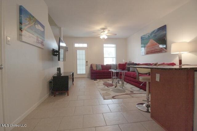 tiled living room featuring ceiling fan