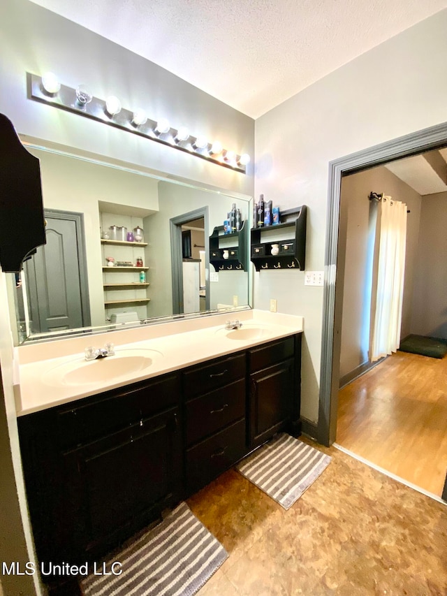 bathroom with vanity, a textured ceiling, and wood-type flooring