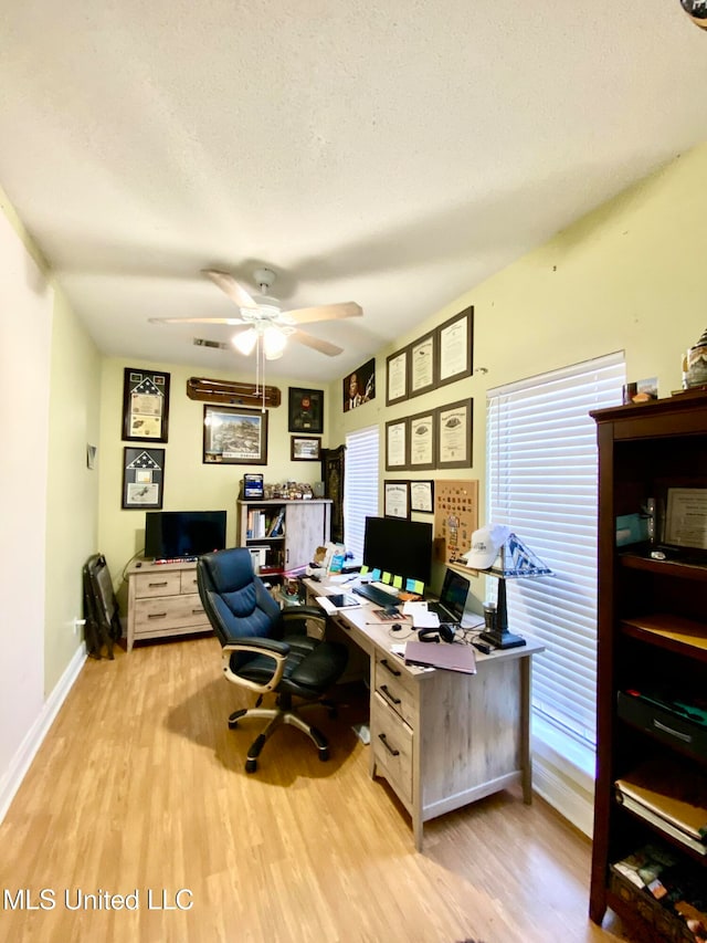 office area featuring a textured ceiling, light wood-type flooring, and ceiling fan