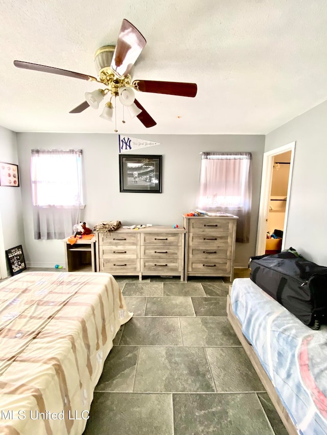 bedroom featuring ceiling fan and a textured ceiling