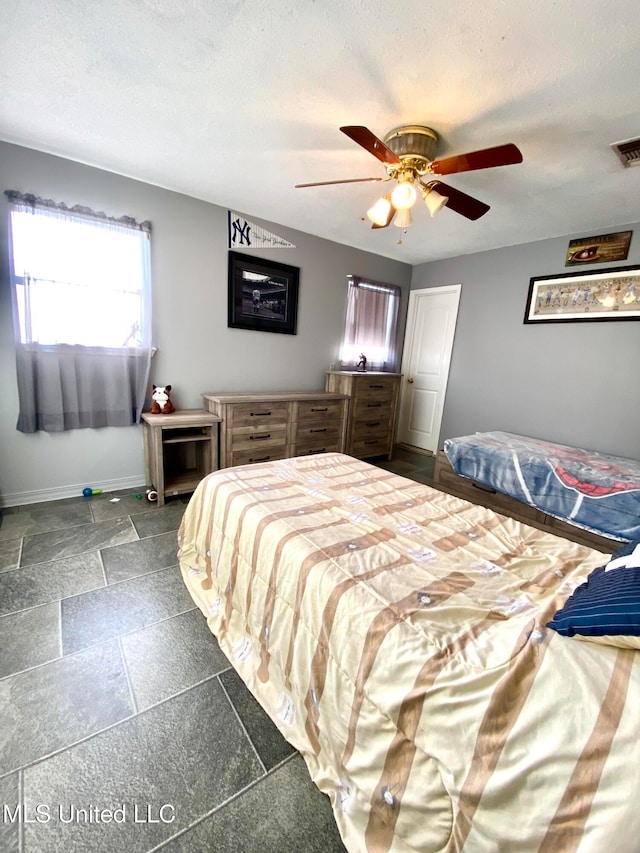 bedroom featuring a textured ceiling and ceiling fan