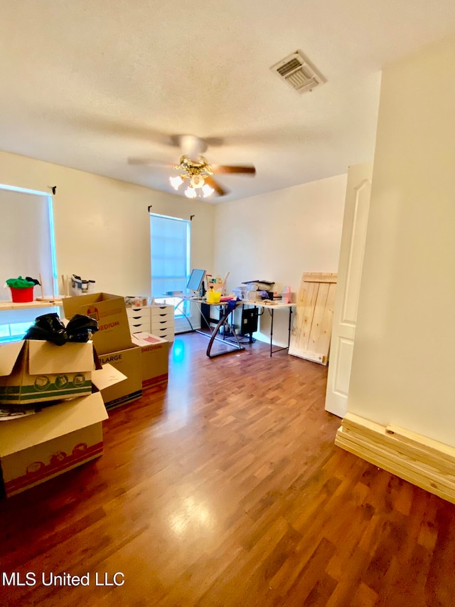 interior space featuring wood-type flooring and ceiling fan