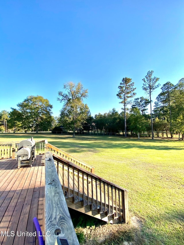 deck featuring area for grilling and a lawn