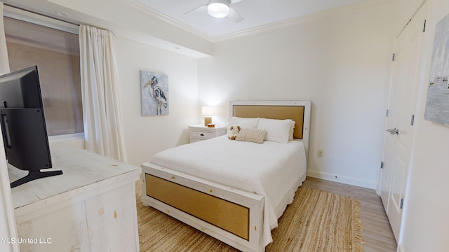 bedroom with ceiling fan, ornamental molding, and light wood-type flooring